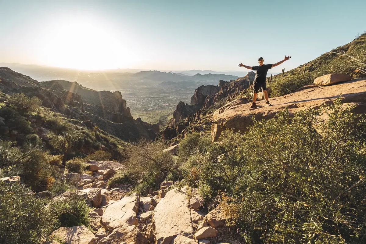 A person on a sunset hike in summer with an outdoor rucksack.